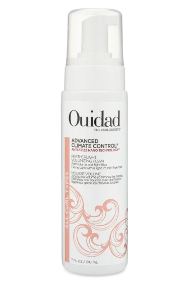 Close-up of a bottle of Ouidad Featherlight Volumizing Foam curly hair product against a transparent background.